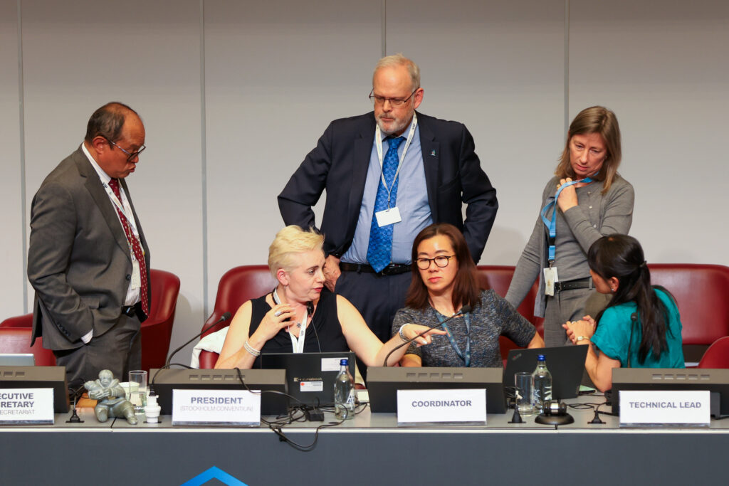 Rolph Payet, Executive Secretary, BRS Conventions, and Stockholm Convention COP12 President Maya Berci, conferring with members of the BRS Secretariat 29 April 2025 Attribution Photo by IISD/ENB | Mike Muzurakis 